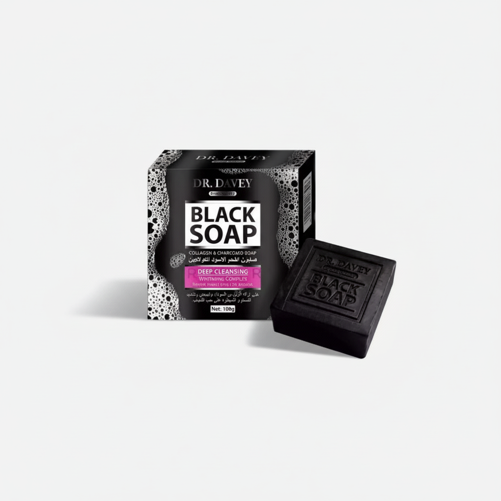 A bar of black soap next to its packaging box, which has 'Dr. Drew's Black Soap' written on it with a decorative pattern.