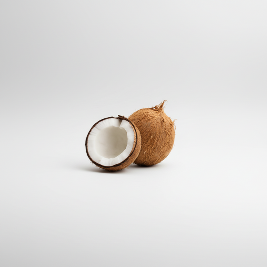 A fresh coconut with a brown husk and a white interior, placed on a white background with a logo and text in the background that reads 'African Grocery Online'.