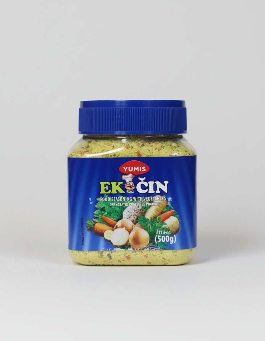 Jar of Yumis Ek Cin food seasoning with vegetables on a blurred background