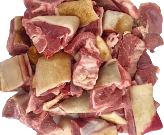 Raw meat chunks and bones on a white background