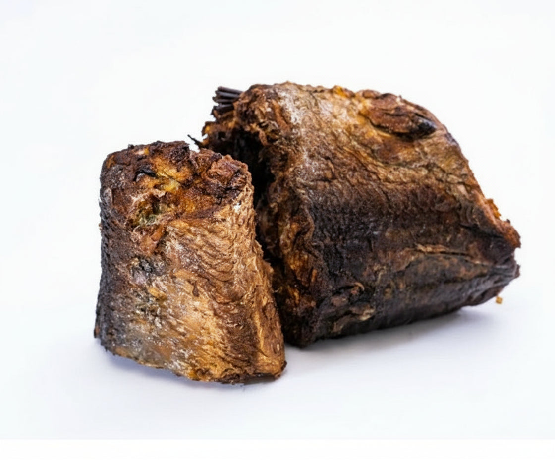 Two pieces of aged, dark brown tea leaves on a white background