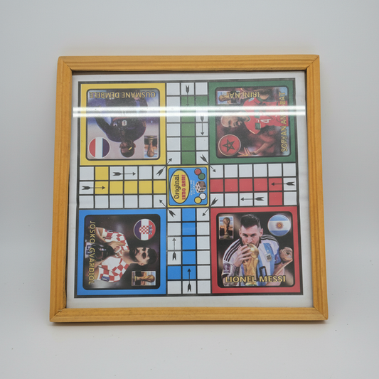 A square wooden-framed board game featuring soccer player cards. The game board has colored squares in white, yellow, green, blue, and red, with player paths and a central 'Original' token area.